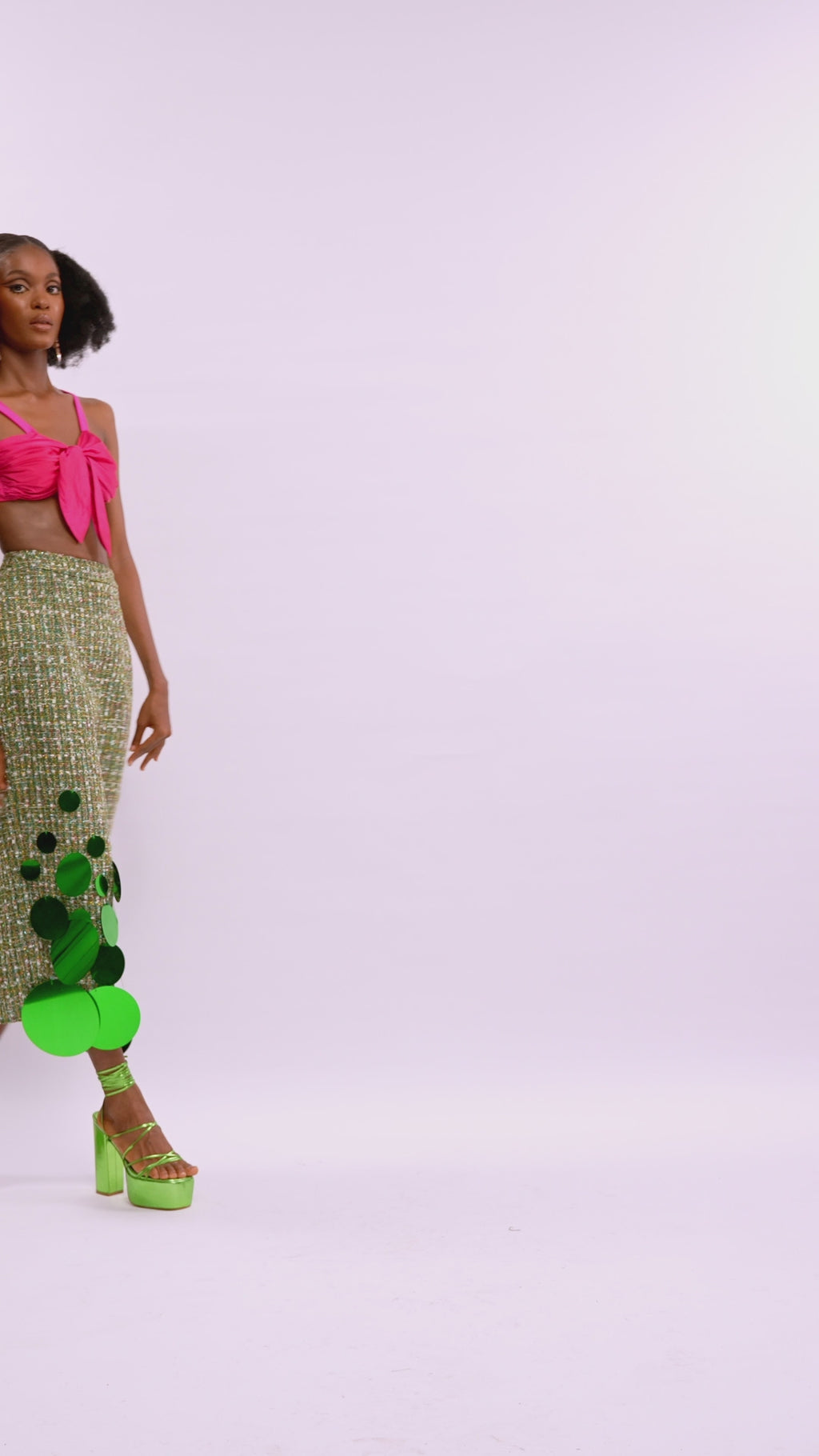 A model wearing a Pink top and a Green skirt with sequins embellishment