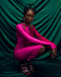 A model wearing a Fuchsia and Pink dress in a green studio