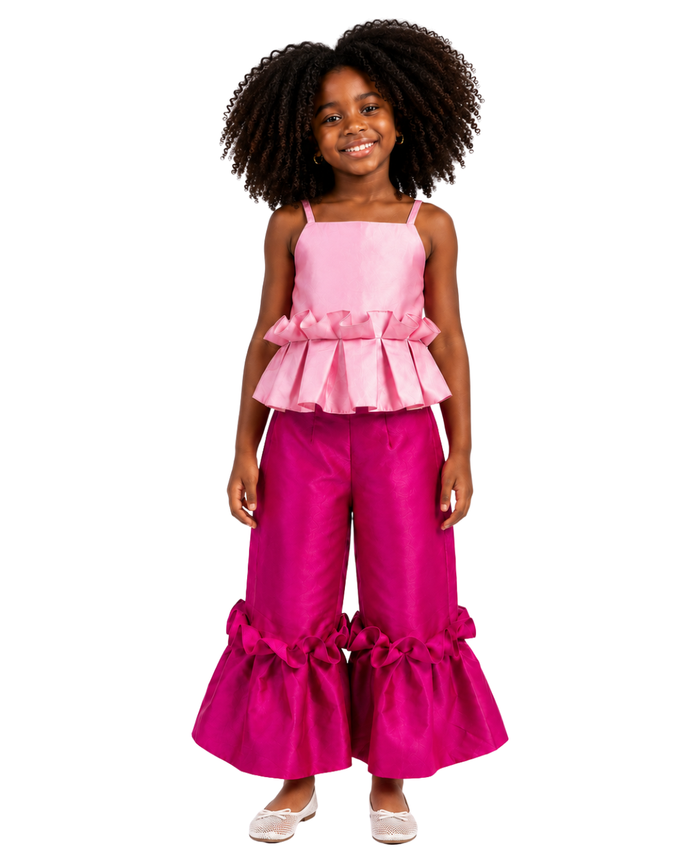 Young girl wearing the Aj peplum top and Ruby ruffle pants set in pink satin from Imad Eduso Kids.