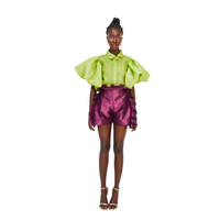A model wearing a lime green top and Aubergine colored shorts with ruffles