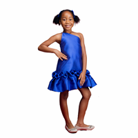 A kid model wearing a one-shoulder blue dress with drop waist ruffle detailing