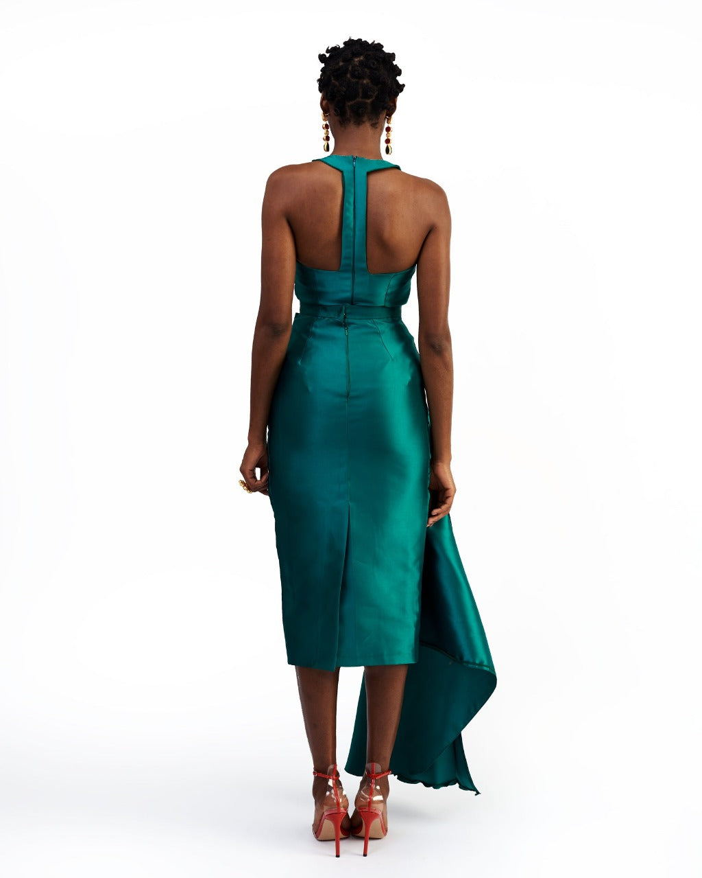 The back of a model wearing a green silk satin top and skirt