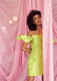 A model wearing a Chartreuse dress with a strap and flare sleeve