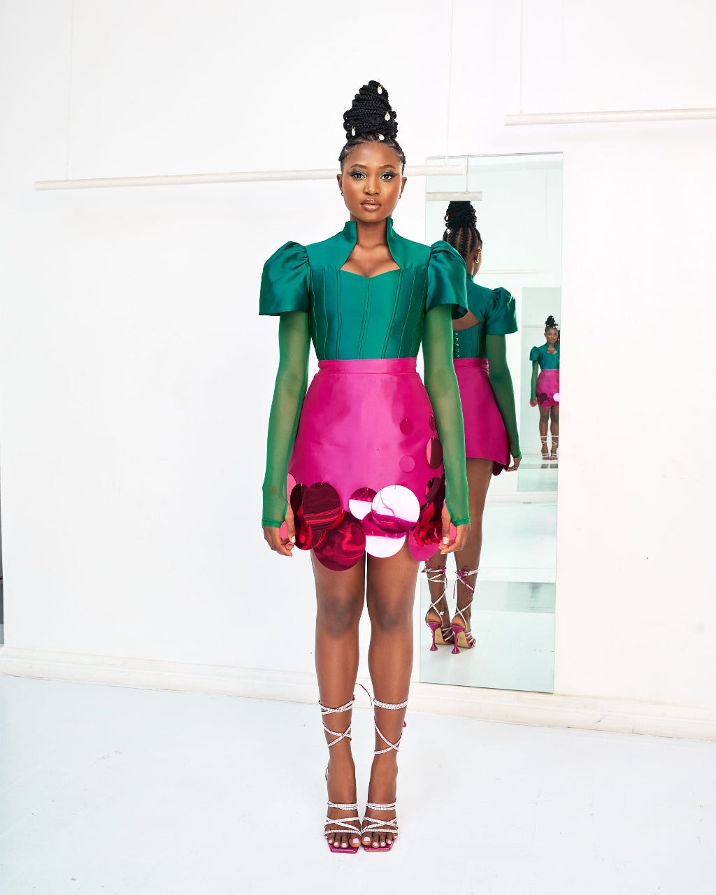 A model wearing a Green top and a Magenta Abeke skirt embellished with sequins