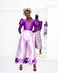 A model wearing a purple Abeke top in a white studio