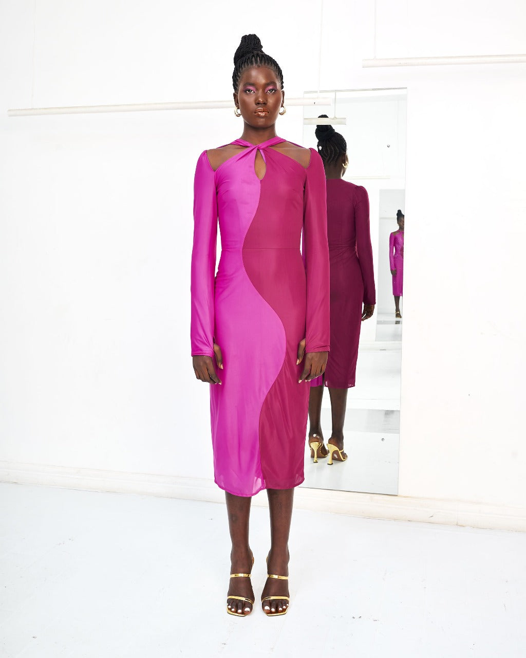 A model wearing a Fuchsia and Pink dress in a white room