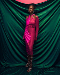 A model wearing a Fuchsia and Pink dress in a green studio