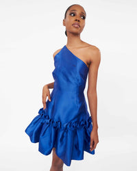 A model wearing a one-shoulder blue dress with drop waist ruffle detailing 