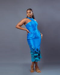 A model wearing a Turquoise top with criss-cross neckline and a Turquoise midi skirt with pleat details at the waist and sequins embellishment
