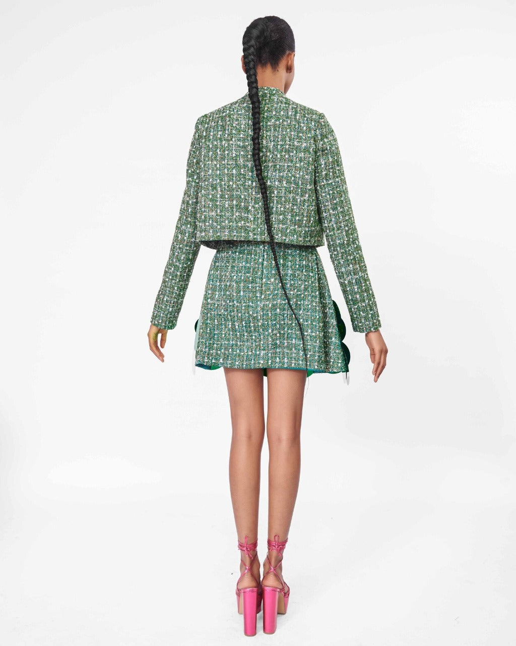 The back of A model wearing a Green, long sleeve crop jacket and Green high waist mini skirt with sequins embellishment