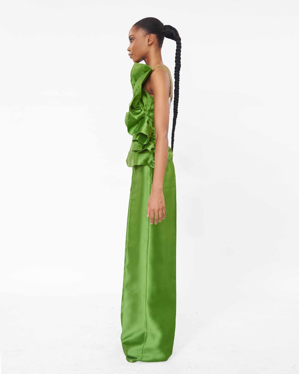 The side of a model wearing an Olive top with ruffle detail and an Olive high waist straight cut pant
