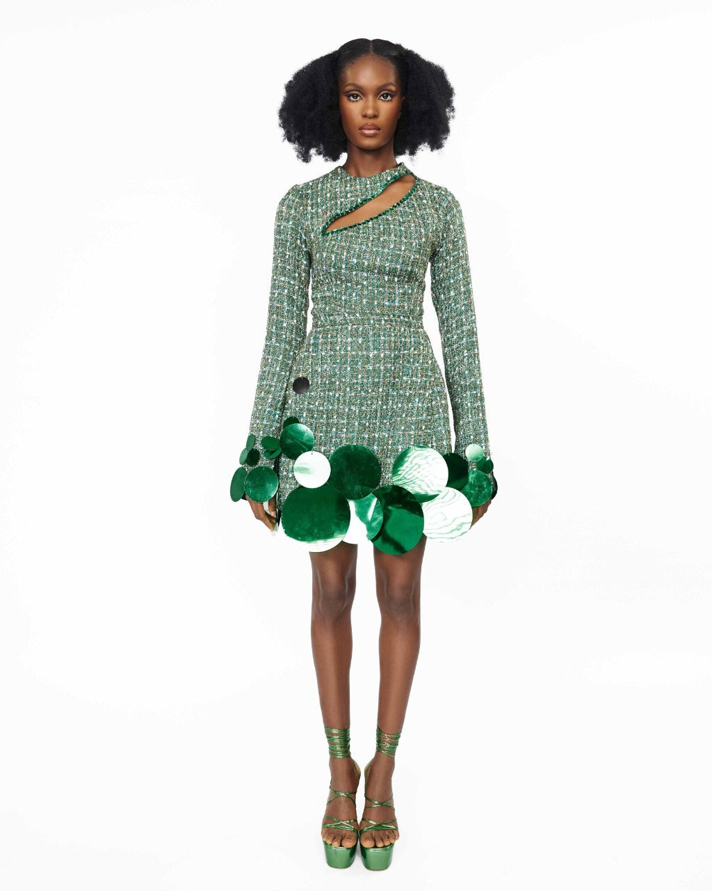 A model wearing a Green top with cut-out neckline detail and sequins embellishment at the neckline and sleeve hem, and Green high waist mini skirt with sequins embellishment