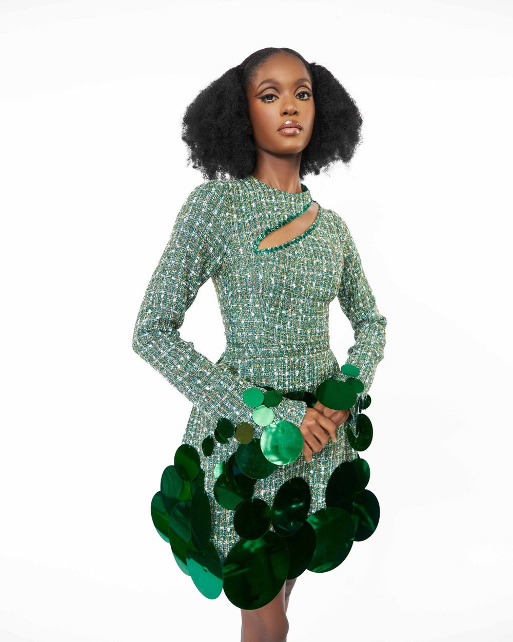 A model wearing a Green top with cut-out neckline detail and sequins embellishment at the neckline and sleeve hem and a Green high waist mini skirt with sequins embellishment