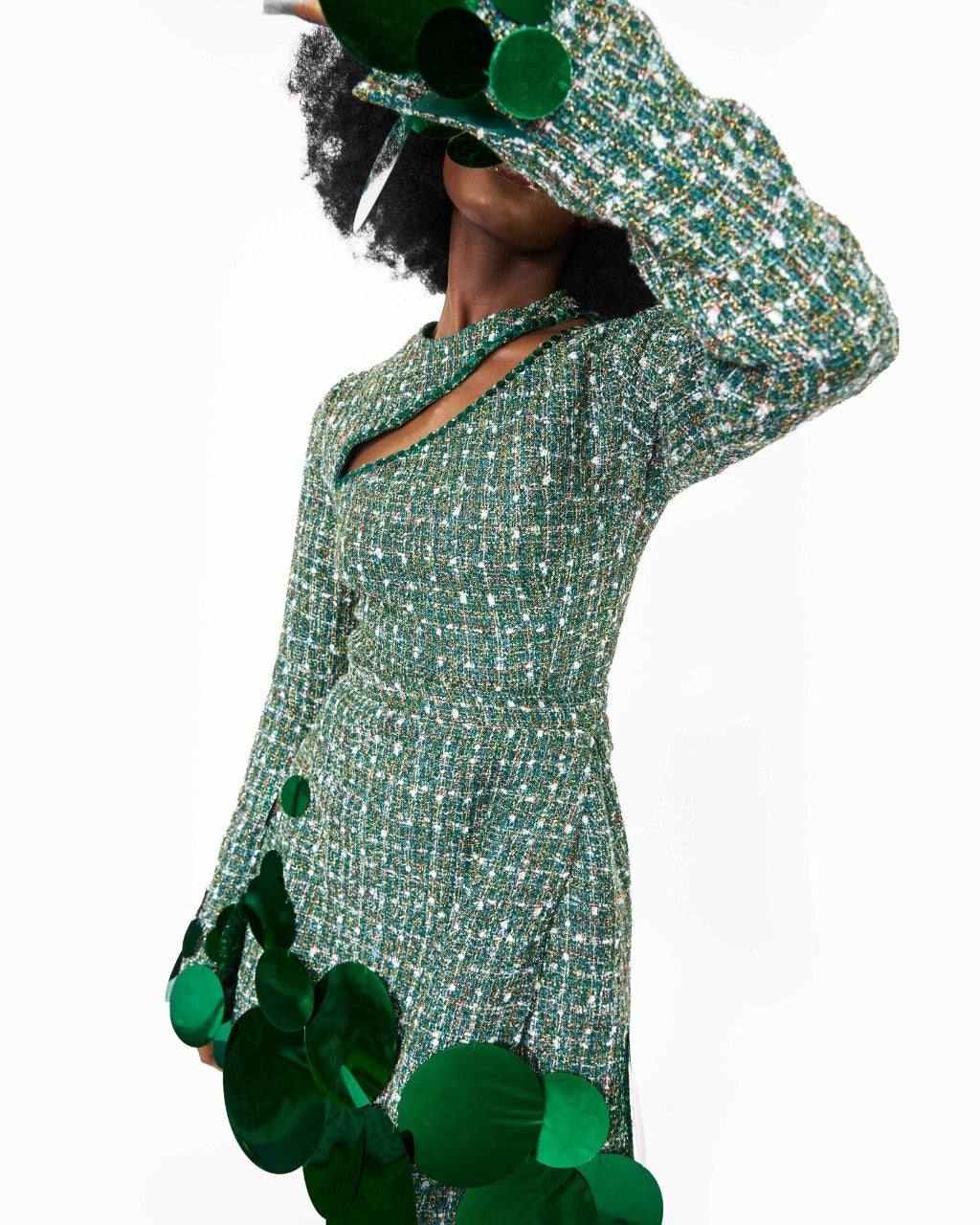 A model wearing a Green top with cut-out neckline detail and sequins embellishment at the neckline and sleeve hem and a Green high waist mini skirt with sequins embellishment