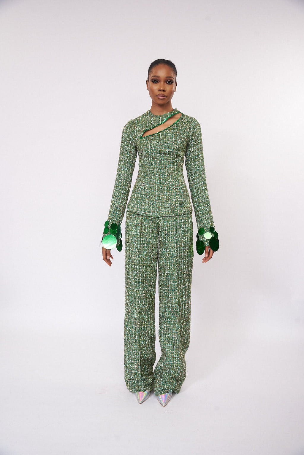 A model wearing a Green top with cut-out neckline detail and sequins embellishment at the neckline and sleeve hem and a Green straight-cut pant