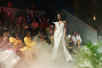 A model wearing a White asymmetric dress with thigh high slit at a fashion show