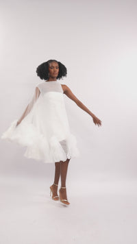 A model wearing a White asymetric sleeve mini dress with ruffles and silk slip lining