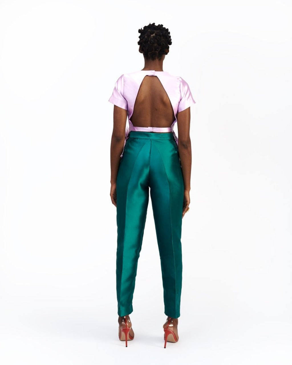 The back of A model wearing green silk satin pants with a purple satin top