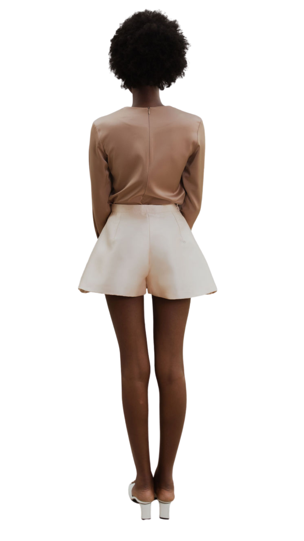 The back of a model wearing a brown top and Nude colored shorts